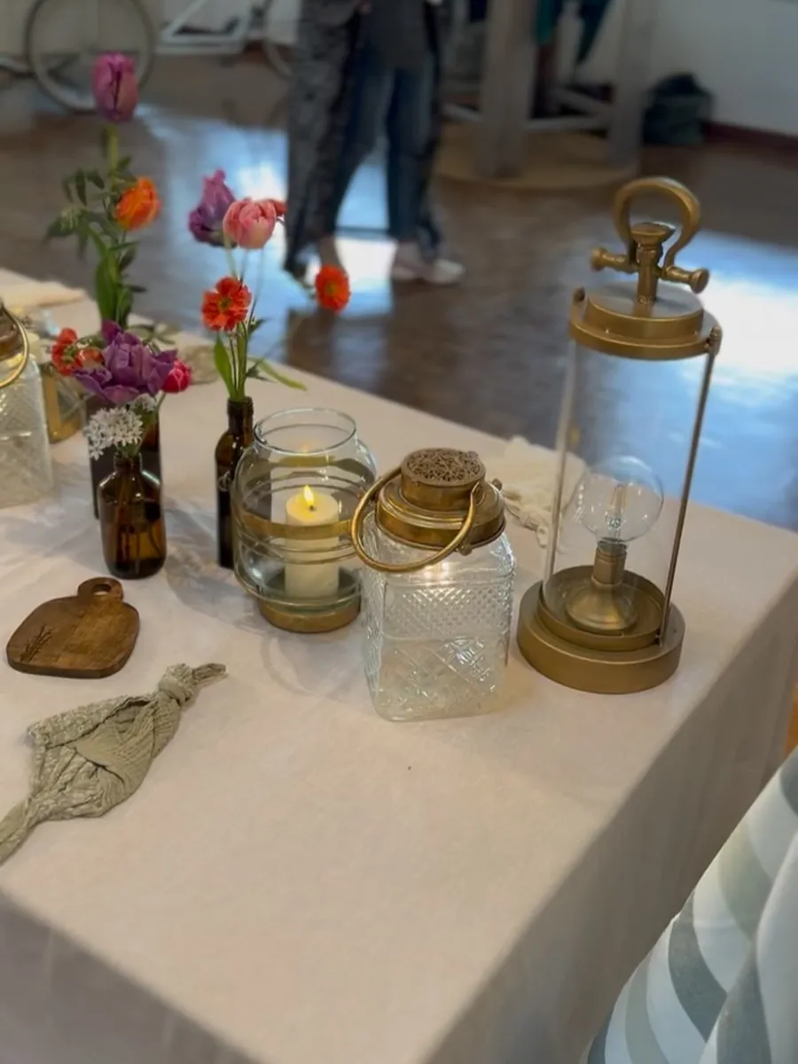 Table de réception décorée de fleurs de saison, bougies et vaisselle dorée